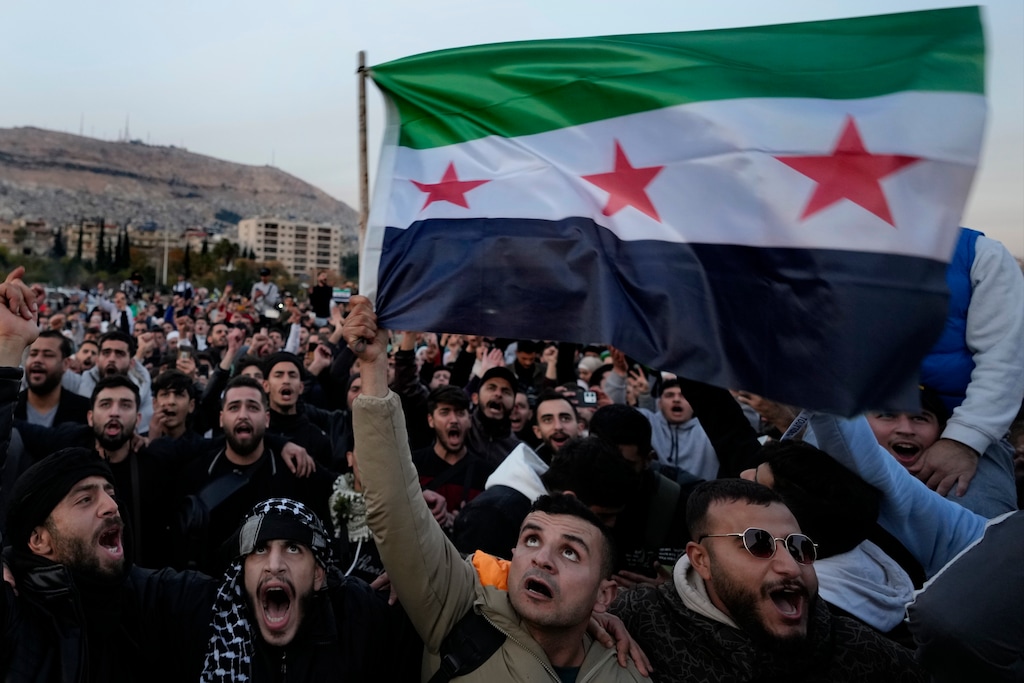 (Hussein Malla | AP) Syrians wave the revolutionary flag and shout slogans as they celebrate during the second day of the takeover of the city by the insurgents in Damascus, Syria, on Dec. 9, 2024.