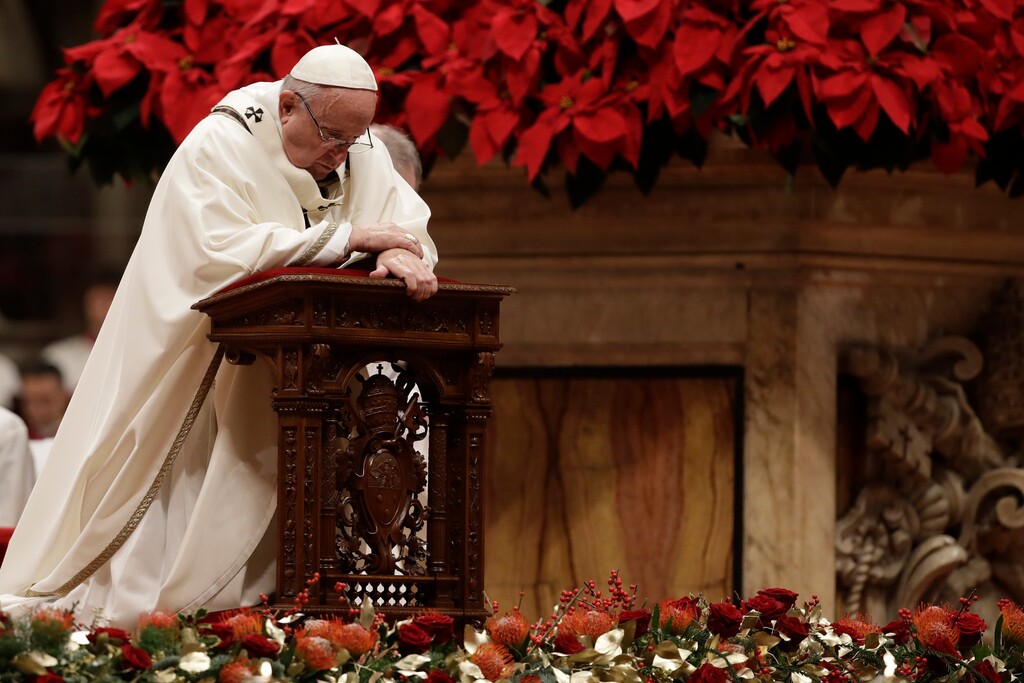 (AP Photo/Alessandra Tarantino) Pope Francis kneels on the altar as he celebrates the Christmas Eve Mass in St. Peter's Basilica at the Vatican, Monday, Dec. 24, 2018.