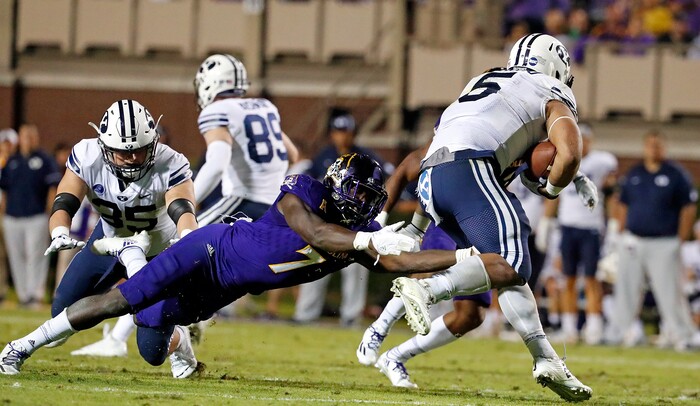 East Carolina's Jordan Williams (7) tries to tie up BYU's Ula Tolutau (5) during the second half of an NCAA college football game in Greenville, N.C., Saturday, Oct. 21, 2017. (AP Photo/Karl B DeBlaker)