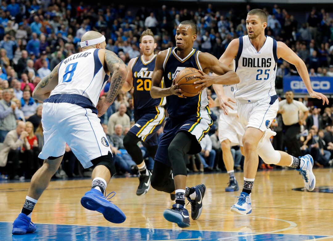 Utah Jazz's Rodney Hood (5) drives to the basket against Dallas Mavericks' Deron Williams (8) for a shot opportunity as Chandler Parsons (25) sprints to help against the play in the second half of an NBA basketball game, Tuesday, Feb. 9, 2016, in Dallas. The Jazz won in overtime 121-119. (AP Photo/Tony Gutierrez)