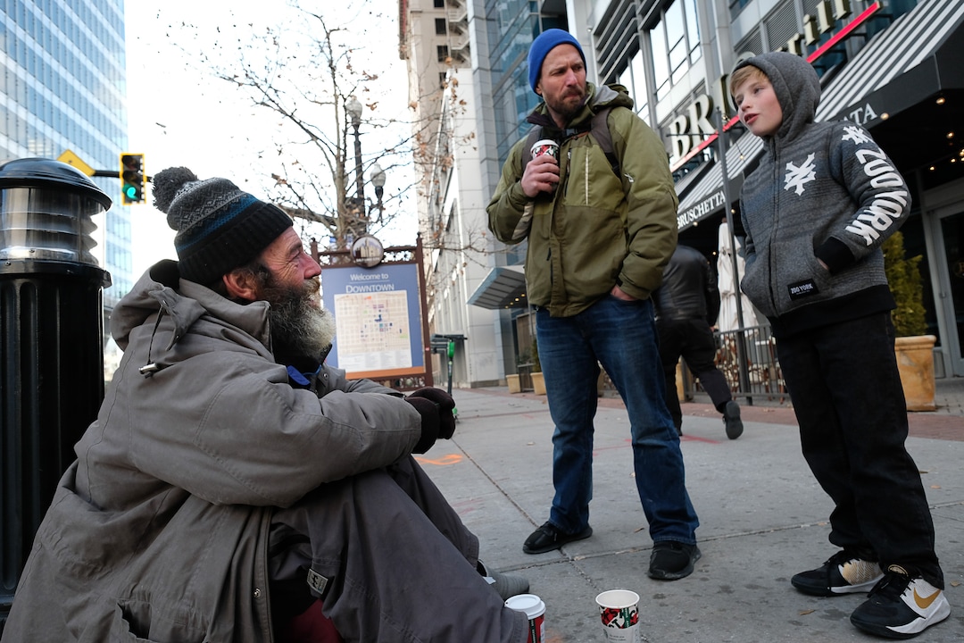 (Francisco Kjolseth  |  The Salt Lake Tribune) Ten-year-old Chase Hansen and his father John who have an organization called Project Empathy, meet Chris Coons in downtown Salt Lake City on Monday, Dec. 16, 2019, as Chase interviews Coons about his life. The two of them spend time with people experiencing homelessness in an effort to connect with people on a personal level. On this occasion Chase learns that Coons used to be an electrician before losing much of his vision and how he loved to ski.