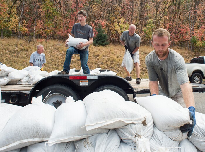 (Rick Egan  |  The Salt Lake Tribune)     Parker Skinner, Marcus Pierce and Dallin Farley work alongside residents of Woodland Hills, stacking sand bags, incase there are flash floods with the coming rain, Monday, Oct. 1, 2018.


