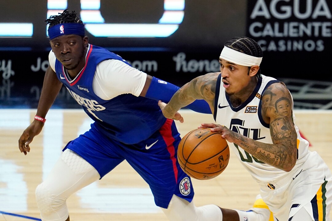 Utah Jazz guard Jordan Clarkson, right, dribbles next to Los Angeles Clippers guard Reggie Jackson during the first half of an NBA basketball game Wednesday, Feb. 17, 2021, in Los Angeles. (AP Photo/Marcio Jose Sanchez)