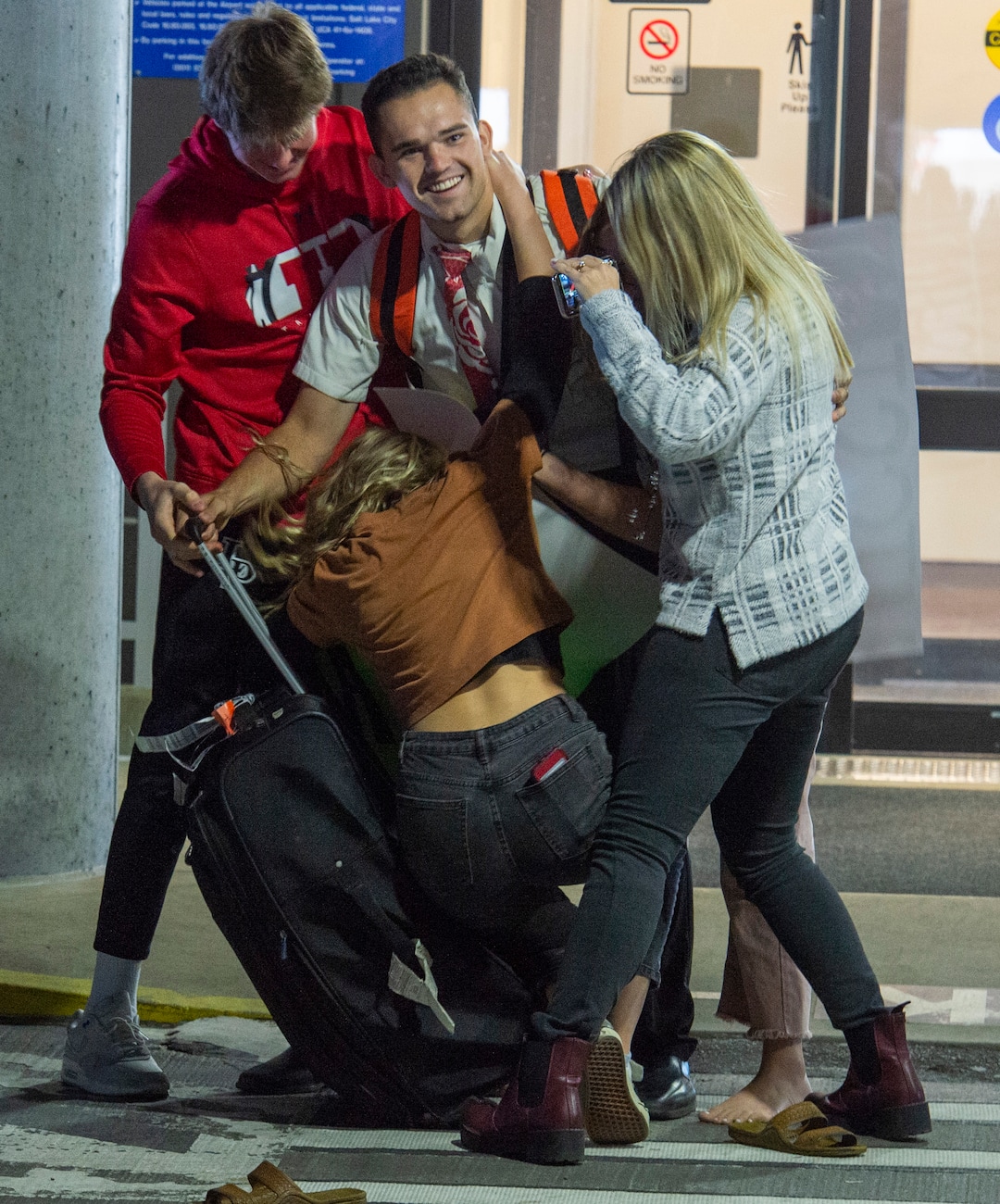 (Rick Egan  |  The Salt Lake Tribune)      Elder Chase Steuer, from Alpine, Utah, is mobbed by family members as he arrives from the Philippines at the Salt Lake City International Airport, Sunday, March 22, 2020.