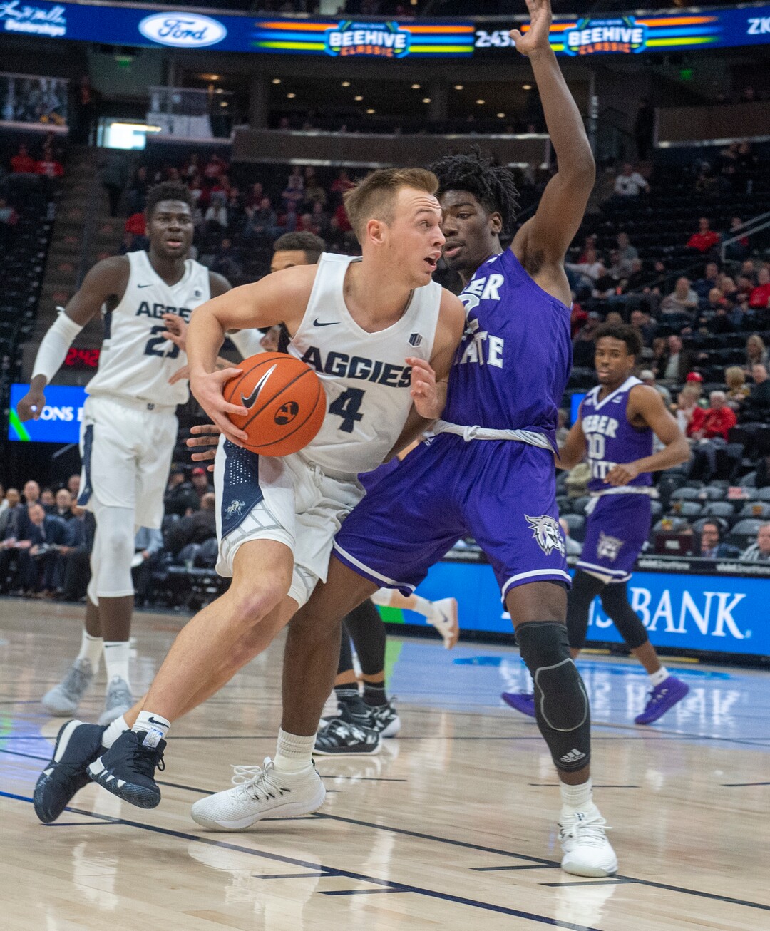(Rick Egan  |  The Salt Lake Tribune)      Utah State Aggies guard Crew Ainge (4) takes the ball down the middle, as Weber State Wildcats guard Israel Barnes (12) defends, in basketball acton in the Beehive Classic, between against the Utah State Aggies and Weber State Wildcats, a the Vivint Smart Home Arena, Saturday December 8, 2018. 