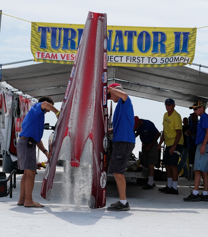(Francisco Kjolseth  |  The Salt Lake Tribune)  Crew of the Vesco Turbinator from Rockville, Utah, dump the accumulated salt from the lower body cover after a test run during Speed Week at the Bonneville Salt Flats outside Wendover on Monday, Aug. 14, 2017. The Turbinator is the fastest wheel driven vehicle with an international speed record of 458 miles per hour. 