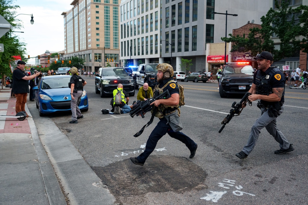 (Trent Nelson | The Salt Lake Tribune) A man lays injured on the street as police respond to the shooting during the "No Kings" march in Salt Lake City Saturday.