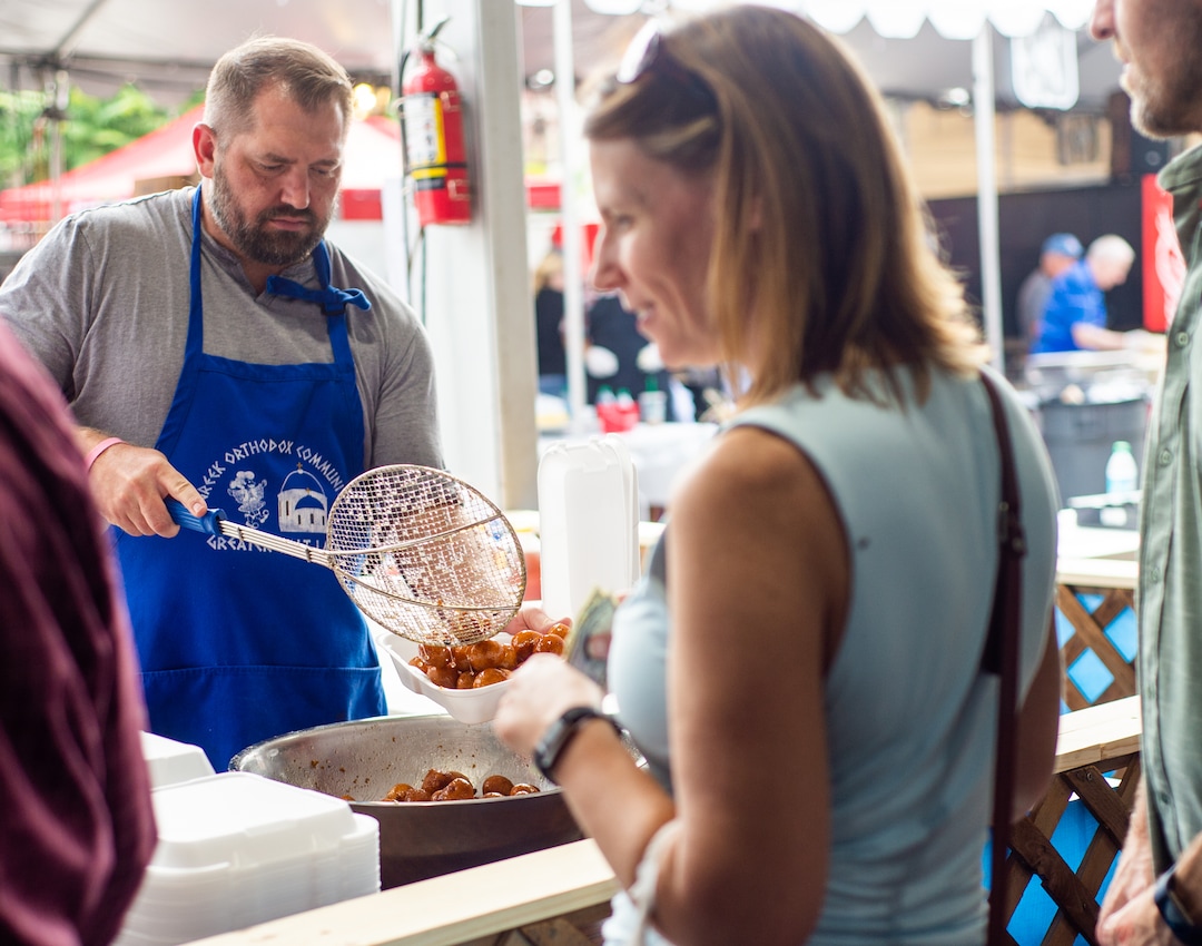 (Rachel Molenda  |  The Salt Lake Tribune) Joel Huff packages a box of loukomades, fried doughnut hole-like scones covered in honey and cinnamon, at the Salt Lake Greek Festival on Saturday, Sept. 8, 2018.
