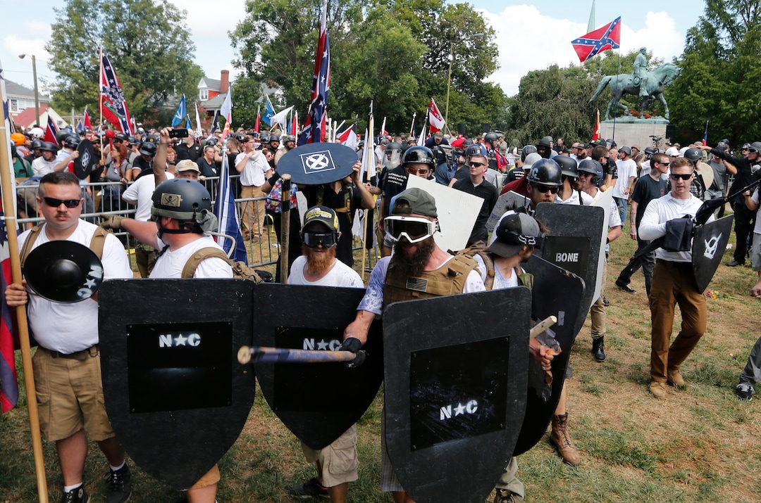 White nationalist demonstrators hold their ground as they clash with counter demonstrators in Lee Park in Charlottesville, Va., Saturday, Aug. 12, 2017.  Hundreds of people chanted, threw punches, hurled water bottles and unleashed chemical sprays on each other Saturday after violence erupted at a white nationalist rally in Virginia. At least one person was arrested.  (AP Photo/Steve Helber)