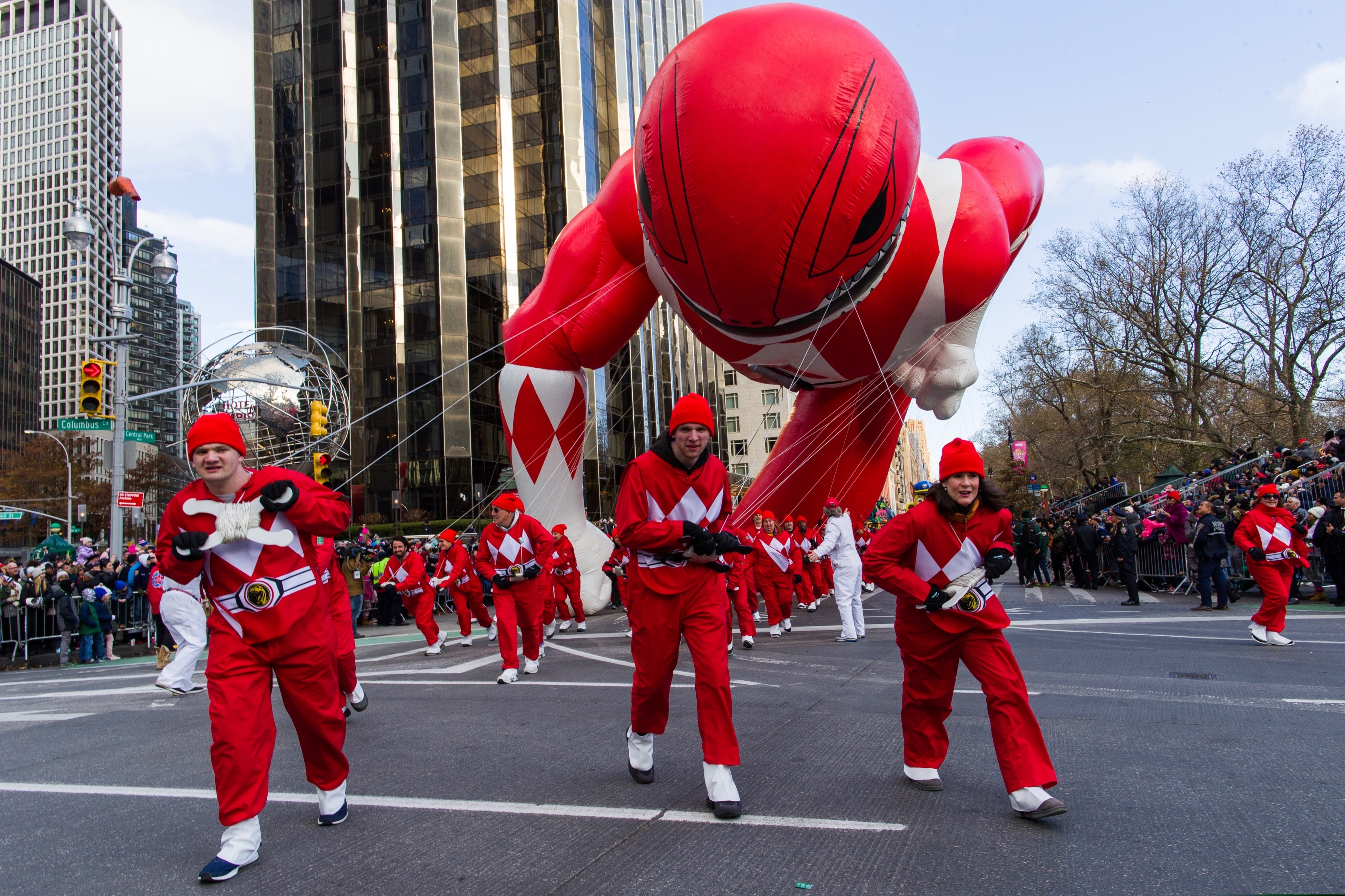 (Eduardo Munoz Alvarez | AP) Parade Volunteers fight with winds as Power Rangers Mighty Morphin Red Ranger balloon makes its way down Columbus Circle during the Macy's Thanksgiving Day Parade, Thursday, Nov. 28, 2019, in New York.