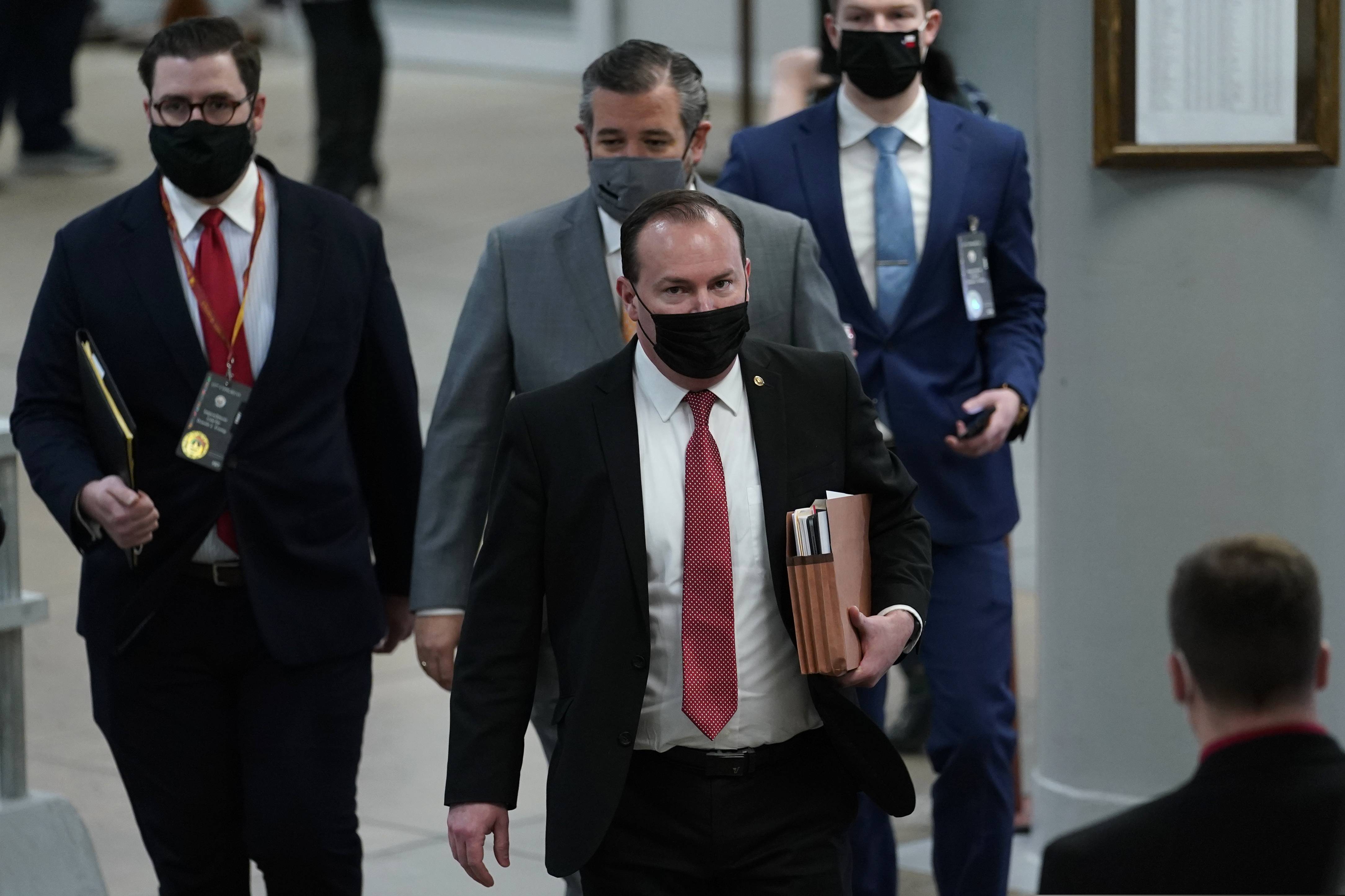 Sen. Mike Lee, R-Utah, followed by Sen. Ted Cruz, R-Texas, walk on Capitol Hill in Washington, Wednesday, Feb. 10, 2021, as they head to the second day of the second impeachment trial of former President Donald Trump. (AP Photo/Susan Walsh)