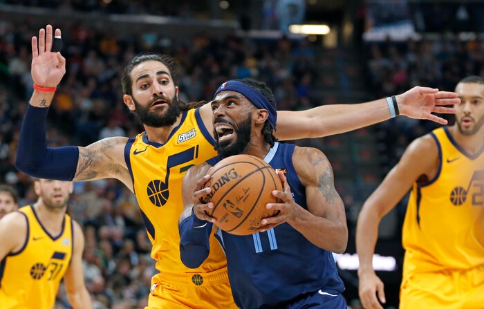Memphis Grizzlies guard Mike Conley (11) drives to the basket as Utah Jazz guard Ricky Rubio, rear, defends in the first half of an NBA basketball game, Monday, Oct. 22, 2018, in Salt Lake City. (AP Photo/Rick Bowmer)