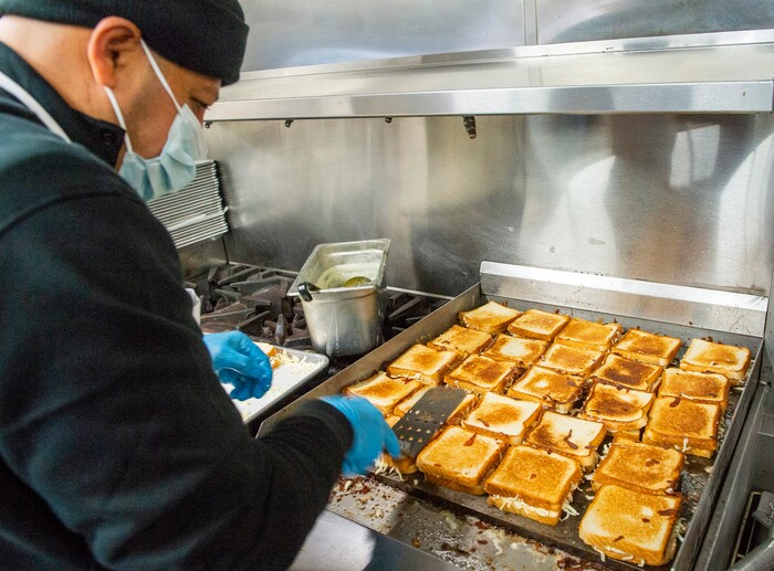(Rick Egan | The Salt Lake Tribune)  Mike Youseff makes grilled cheese sandwiches for 600 health care workers as part of the the Curds + Kindness program, which supports local dairy farmers, at the South Jordan Health Center in Daybreak on Tuesday, Dec. 1, 2020.