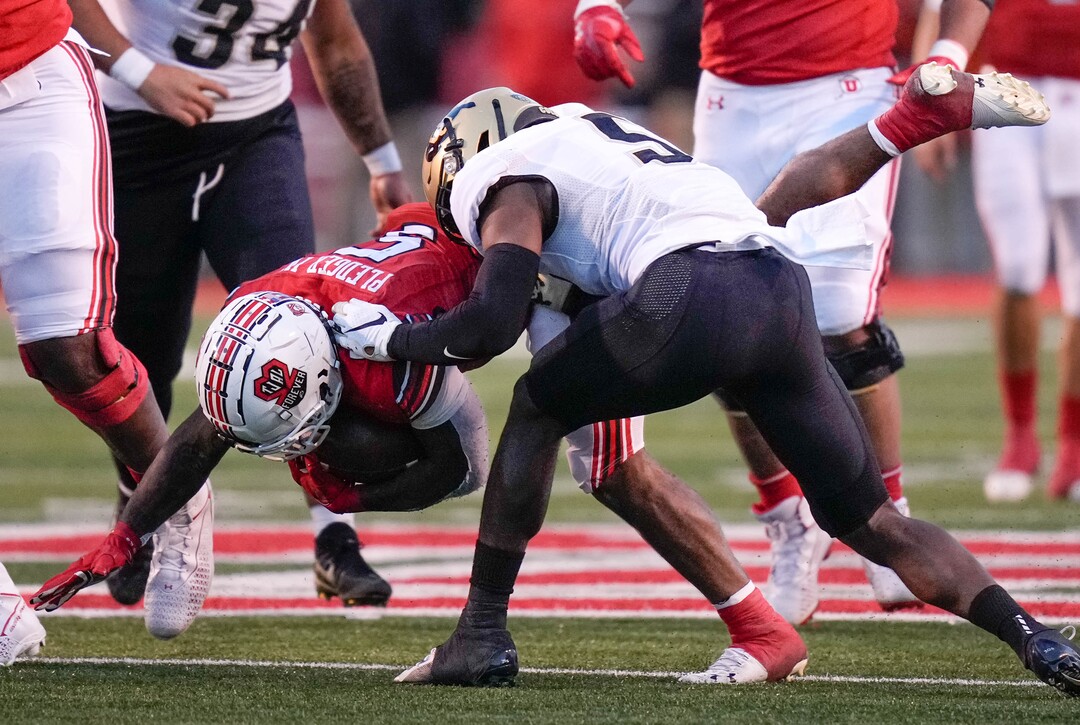 (Francisco Kjolseth | The Salt Lake Tribune) Utah Utes running back TJ Pledger (5) is brought down by Colorado Buffaloes safety Mark Perry (5) as Utah hosts the Colorado Buffaloes in Pac-12 football, Friday, Nov. 26, 2021 at Rice-Eccles Stadium.