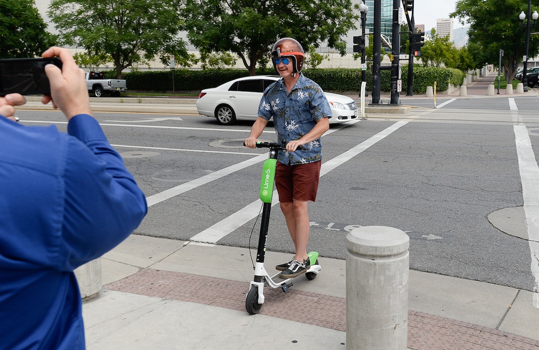 (Francisco Kjolseth  |  The Salt Lake Tribune)  Salt Lake Tribune columnist Robert Gehrke finishes his race against colleagues during a downtown transportation race from Library Square to the Tribune building at the Gateway on Thursday, Aug. 2, 2018. Modes of transportation included, rentable electric scooters, Green Bike, TRAX, Lyft, and walking.
