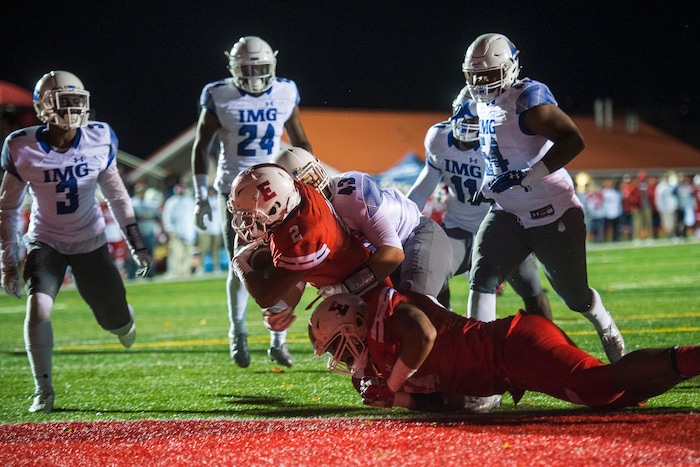 (Chris Detrick  |  The Salt Lake Tribune)  East's Sione Molisi (2) scores a touchdown past IMG Academy's Nick Wiebe (43) during the game at East High School Friday, October 20, 2017. 