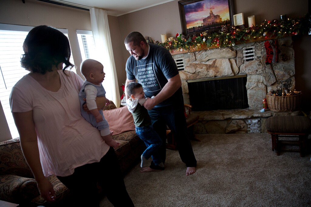 (Sammy Jo Hester | For The Washington Post) Ashlee and Levi Smith play with their sons Liam, 3, and Aiden, 3 months, on Sunday in Salem, Utah. The family has relied on the government-backed Children's Health Insurance Program.