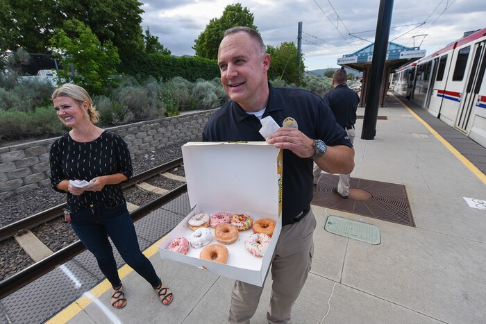 (Francisco Kjolseth | The Salt Lake Tribune) Interim Sandy Police Chief Bill O'Neal tries to entice morning commuters into a free donut In honor of National Donut Day while joined by Deputy Mayor Evelyn Everton on Friday, June 1, 2018, at the Sandy Civic Center TRAX Station. The Sandy Police department and Sandy Mayor Kurt Bradburn teamed up in an effort to create positive interactions with residents.
