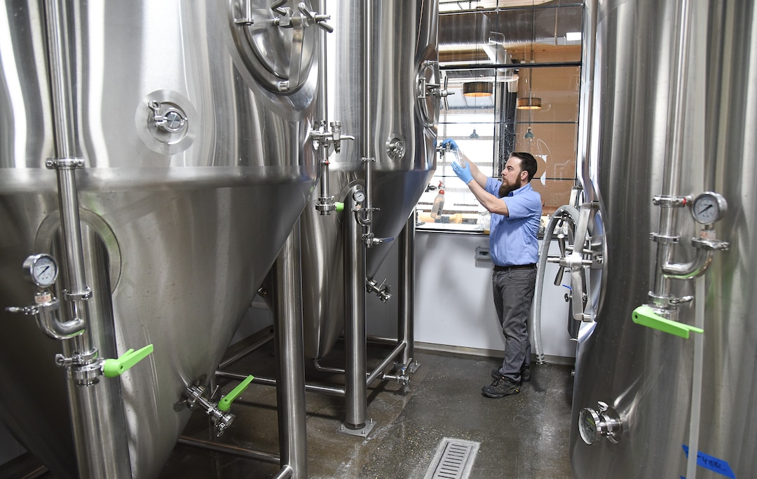 (Francisco Kjolseth  |  The Salt Lake Tribune)  Chris Detrick, head brewer for Level Crossing Brewing Co. checks to see if fermentation is complete.