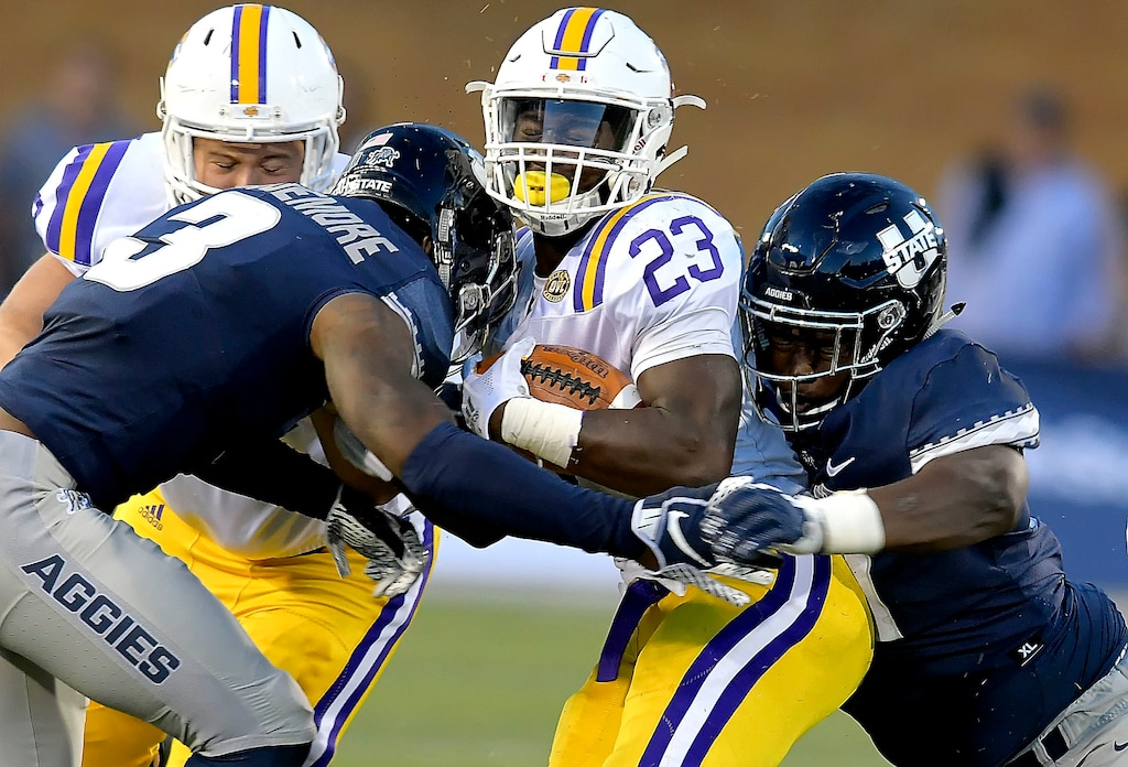 (Eli Lucero/Herald Journal via AP) Utah State safety Jontrell Rocquemore (3) and defensive end Devon Anderson tackle Tennessee Tech running back Andrew Goldsmith (23) during an NCAA football game, Thursday, Sept. 13, 2018, in Logan, Utah.
