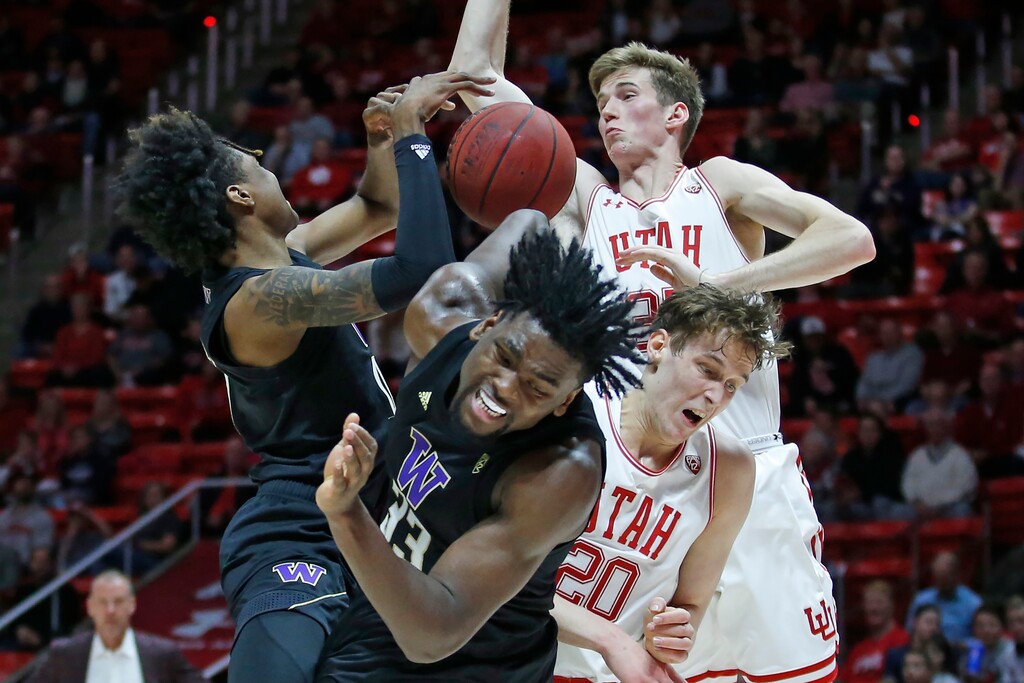 Washington's Jaden McDaniels, left, and Isaiah Stewart (33) battle against Utah's Mikael Jantunen (20)and Branden Carlson, rear, for a rebound in the first half during an NCAA college basketball game Thursday, Jan. 23, 2020, in Salt Lake City. (AP Photo/Rick Bowmer)