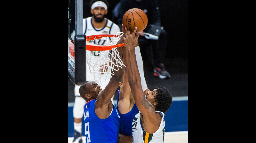 (Rick Egan | The Salt Lake Tribune) LA Clippers forward Serge Ibaka (9) sticks his hand inside the hoop to stop Utah Jazz center Derrick Favors (15) from scoring, in NBA action between the Utah Jazz and the LA Clippers at Vivint Arena, on Friday, Jan. 1, 2021.