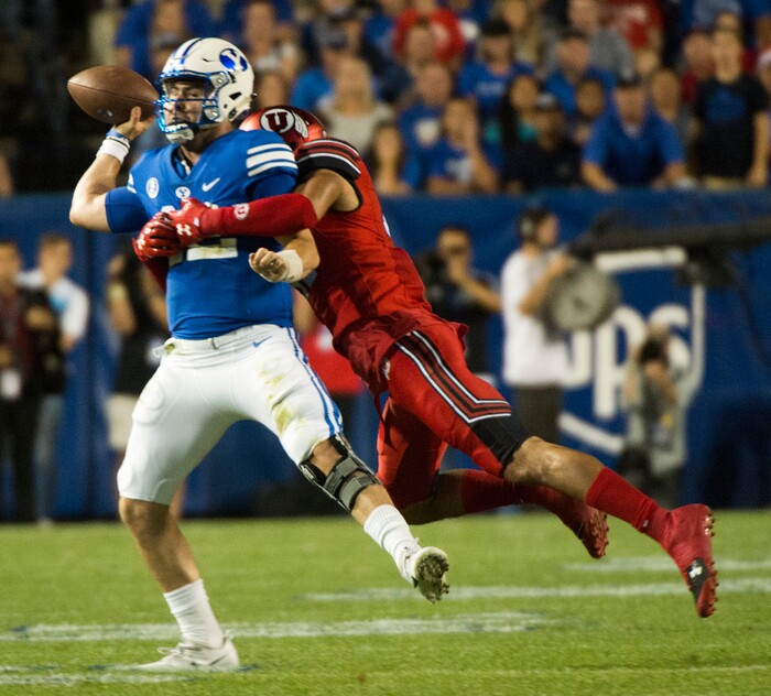 (Rick Egan  |  The Salt Lake Tribune)   Brigham Young Cougars quarterback Tanner Mangum (12) is chased by Utah Utes defensive end Caleb Repp (47), football action BYU vs Utah, at Lavell Edwards Stadium in Provo, Saturday, September 9, 2017.