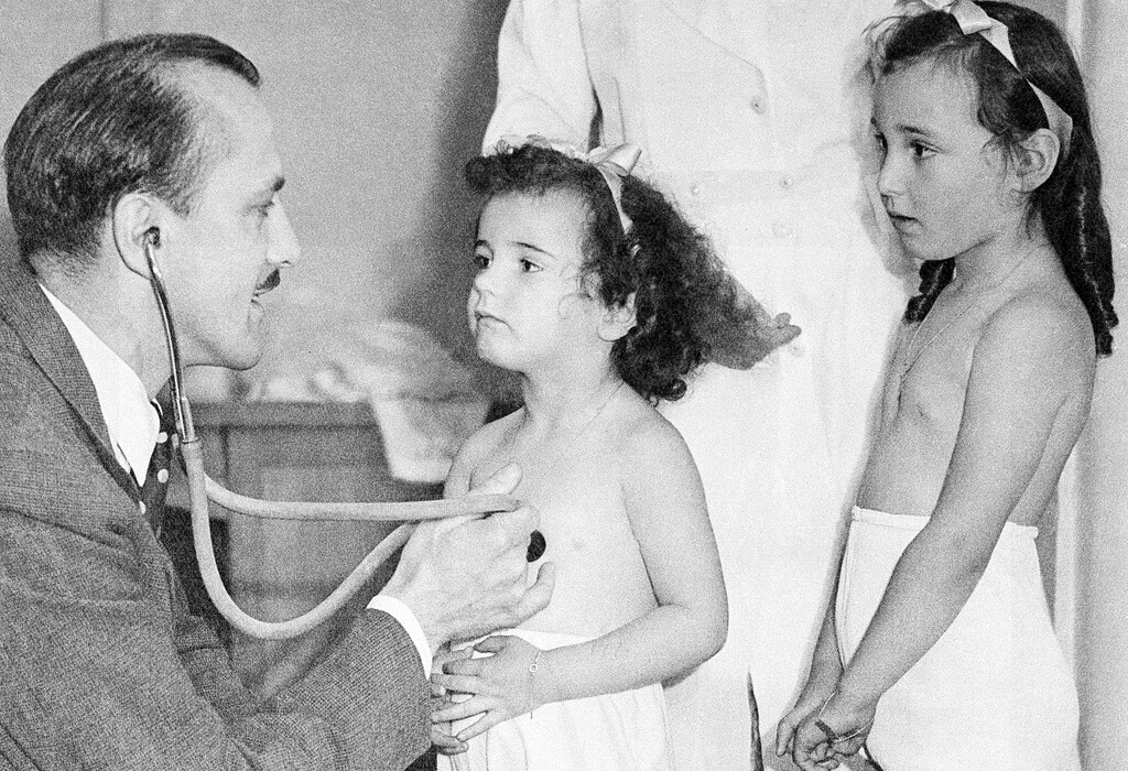 (The Associated Press) A physician examines two sisters seeking to escape the war by going to the United States. They are in London July 1, 1940 in a special office set up for examination of those children whose parents applied fro their removal to the new world.