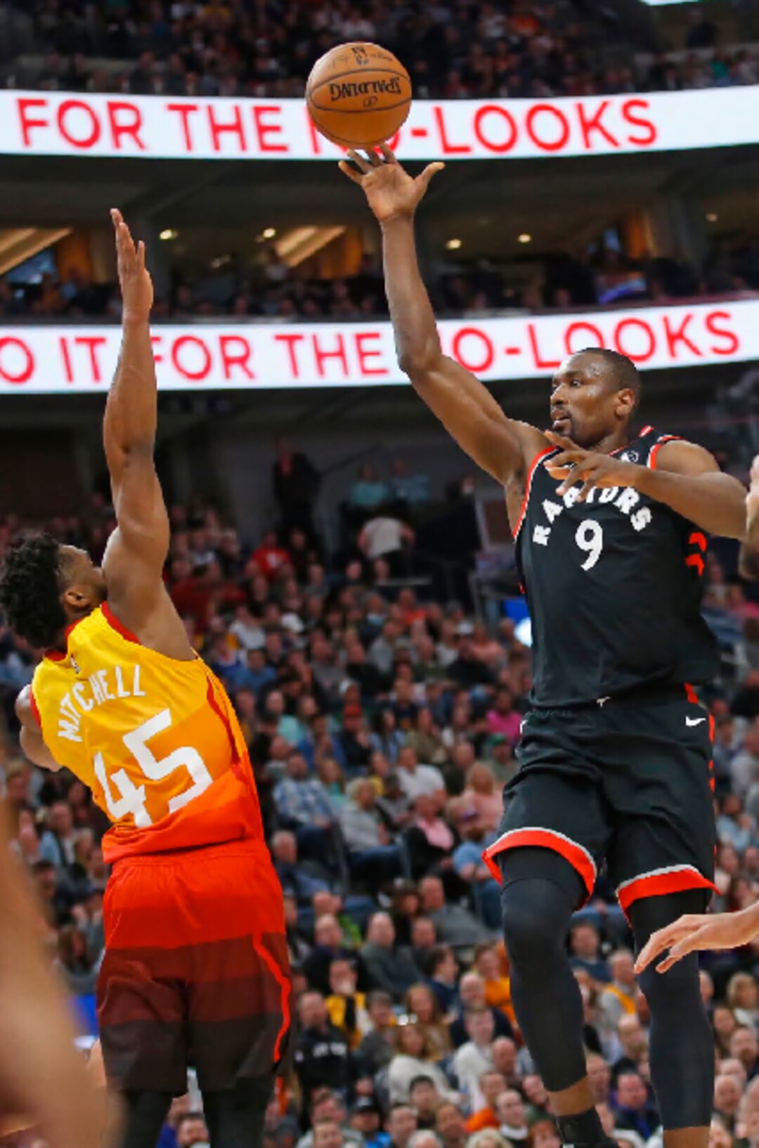 Toronto Raptors center Serge Ibaka (9) shoots over Utah Jazz guard Donovan Mitchell (45) in the first half of an NBA basketball game, Monday, March 9, 2020, in Salt Lake City. (AP Photo/Rick Bowmer)