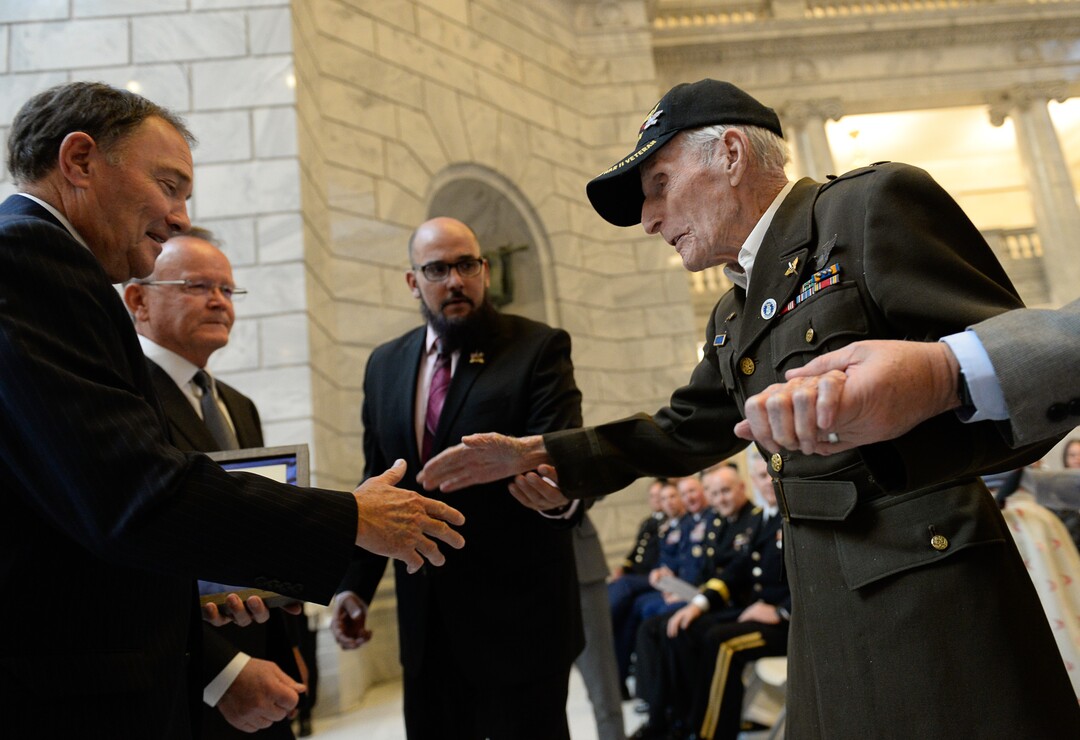 (Francisco Kjolseth  |  The Salt Lake Tribune)  Dan Eastman, 99, who flew 28 combat missions, including D-Day is presented a commanders coin by Governor Gary Herbert and Utah State Senate President Stuard Adams during a veterans centenarian celebration, honoring over twenty veterans 99 and over in Utah at the State Capitol Rotunda on Tuesday, Nov. 5, 2019.