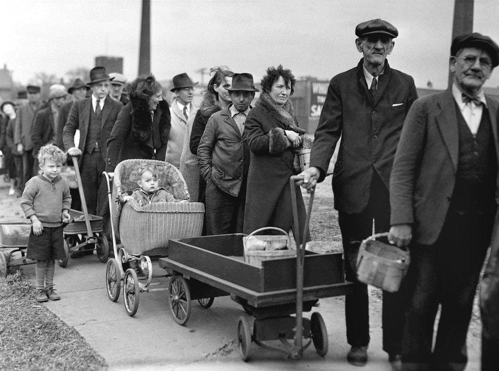 (AP file photo) In this May 9, 1938, photo, people stand in line for their portions of a federal surplus of potatoes and cabbages in Cleveland. Nearly a century later, the U.S. economy is all but shut down, and layoffs are soaring at small businesses and major industries. A devastating global recession looks inevitable. Deepening the threat, a global oil price war has erupted. Some economists foresee an economic downturn to rival the Depression.