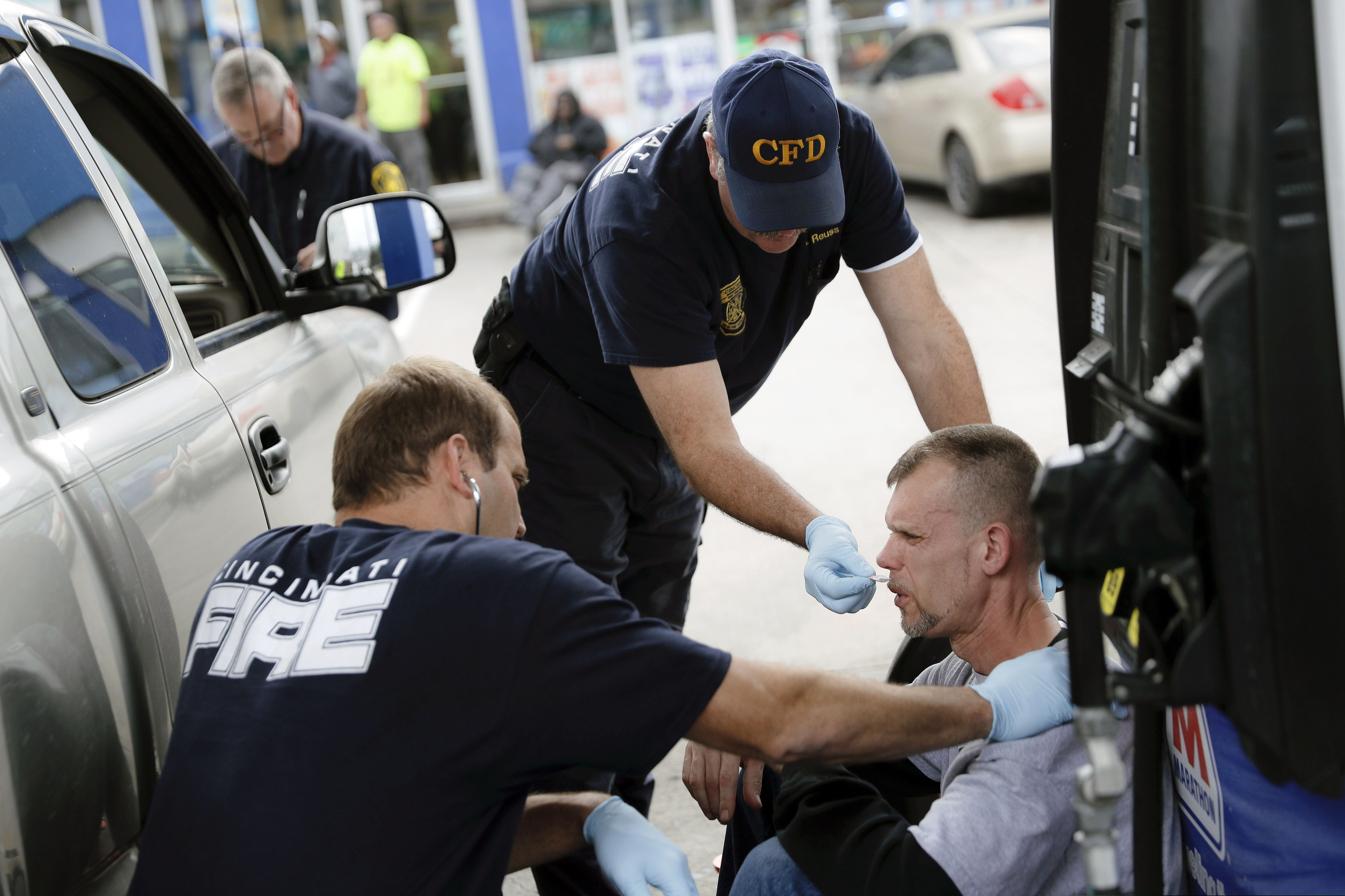(John Minchillo | AP file photo) Medics with the Cincinnati Fire Department work to keep a possible overdose victim awake after administering Naloxone while responding to a call at a gas station in downtown Cincinnati, Nov. 2, 2017. Reports emerging about a possible financial settlement in 2019 with Purdue Pharma, the company that has come to symbolize the nation's opioid epidemic, suggests the settlement amount won't come anywhere near what the national crisis has cost.