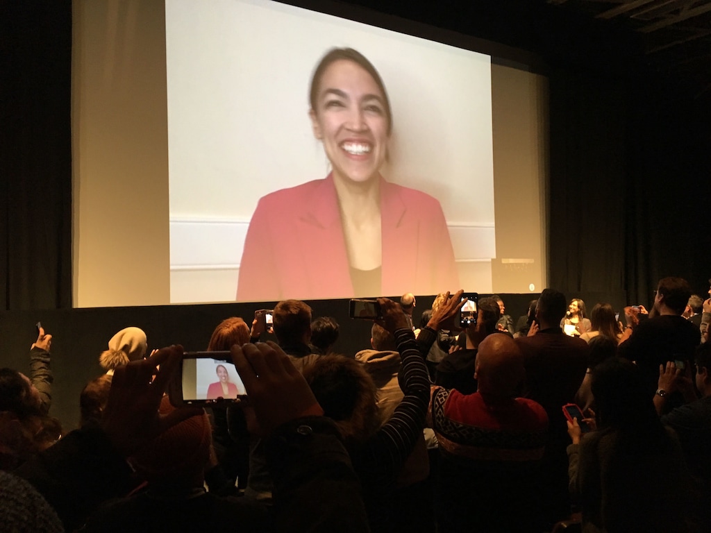(Sean P. Means | The Salt Lake Tribune) 
 Rep. Alexandria Ocasio-Cortez, D-N.Y., piped in from Washington, D.C., smiles as patrons at the 2019 Sundance Film Festival give a standing ovation to the documentary “Knock Down the House,” which premiered Sunday at The MARC Theatre in Park City.