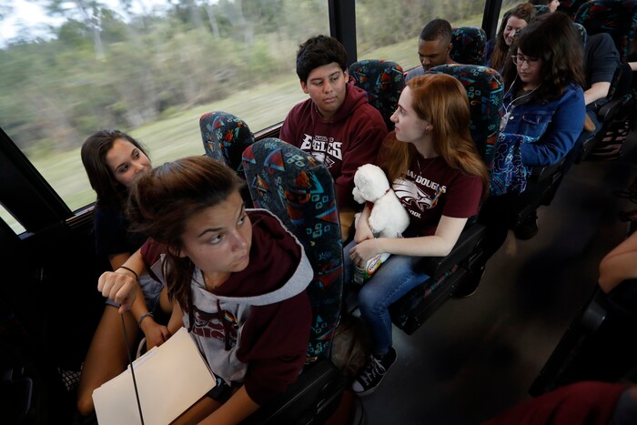 Julia Salomone, 18, front row left, Lindsey Salomone, 15, front row right, Jose Iglesias, 17, second row left, and Isabelle Robinson, 17, second row right, student survivors from Marjory Stoneman Douglas High School, where 17 students and faculty were killed in a mass shooting on Wednesday, talk on their bus between Parkland, Fla., and Tallahassee, Fla., Tuesday, Feb. 20, 2018, to rally outside the state capitol and talk to legislators about gun control reform. Nikolas Cruz, a former student, was charged with 17 counts of premeditated murder on Thursday. (AP Photo/Gerald Herbert)