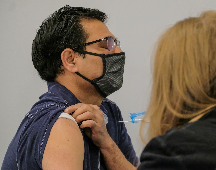 (Leah Hogsten | The Salt Lake Tribune) Aslam Khan, 52, shuts his eyes tightly as he receives his first free Moderna vaccination from Kimberly Desmond with Salt Lake County Health Department on Thursday. Over 120 people were scheduled to get their first shots of both the Moderna and Pfizer vaccines at the Utah Islamic Center in West Jordan, Mar. 18, 2021.