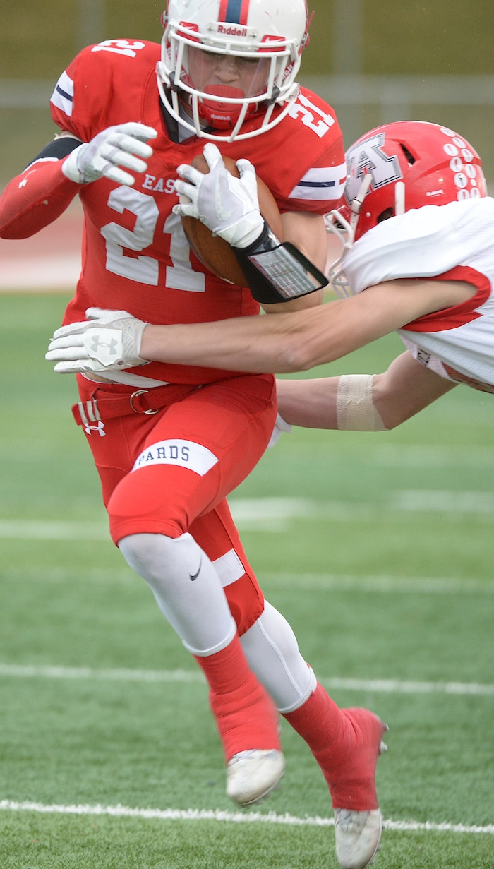 (Leah Hogsten  |  The Salt Lake Tribune) East's Charlie Vincent slips past Preston Viehwig. American Fork High School boys' football team East High School during their class 6A state quarterfinal football game, Friday, November 3, 2017