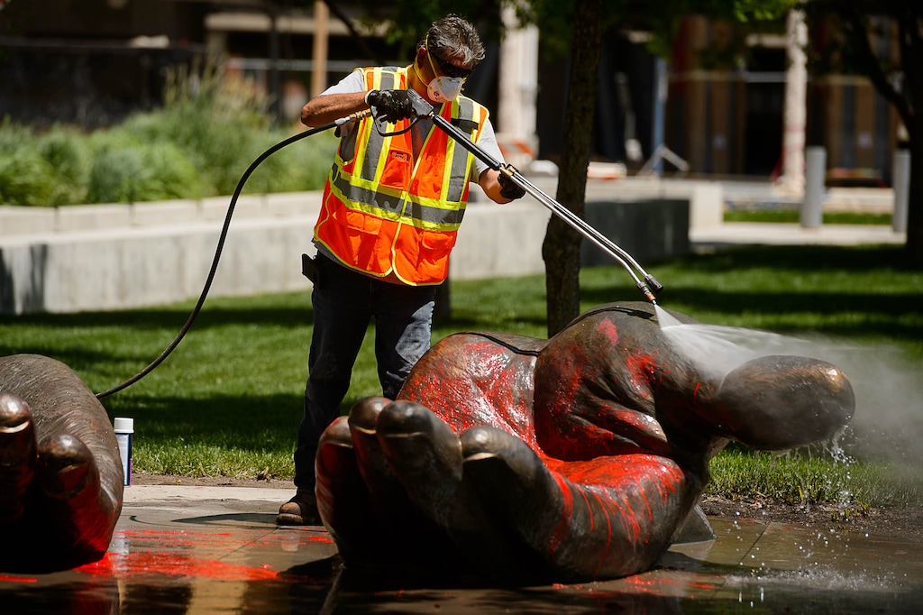 (Trent Nelson  |  The Salt Lake Tribune) A worker washes a sculpture at the Public Safety Building as cleanup takes place the day after a rally against police brutality turned violent in Salt Lake City on Saturday, May 30, 2020.