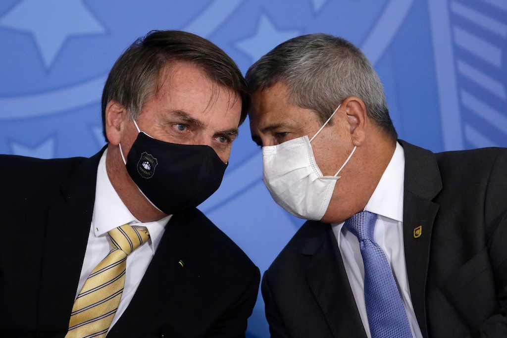 Brazil's President Jair Bolsonaro, left, talks with his Chief of Staff Braga Neto, both wearing masks due to the COVID-19 pandemic, at an event promoting a government campaign against domestic violence at Planalto presidential palace in Brasilia, Brazil, Friday, May 15, 2020. (AP Photo/Eraldo Peres)
