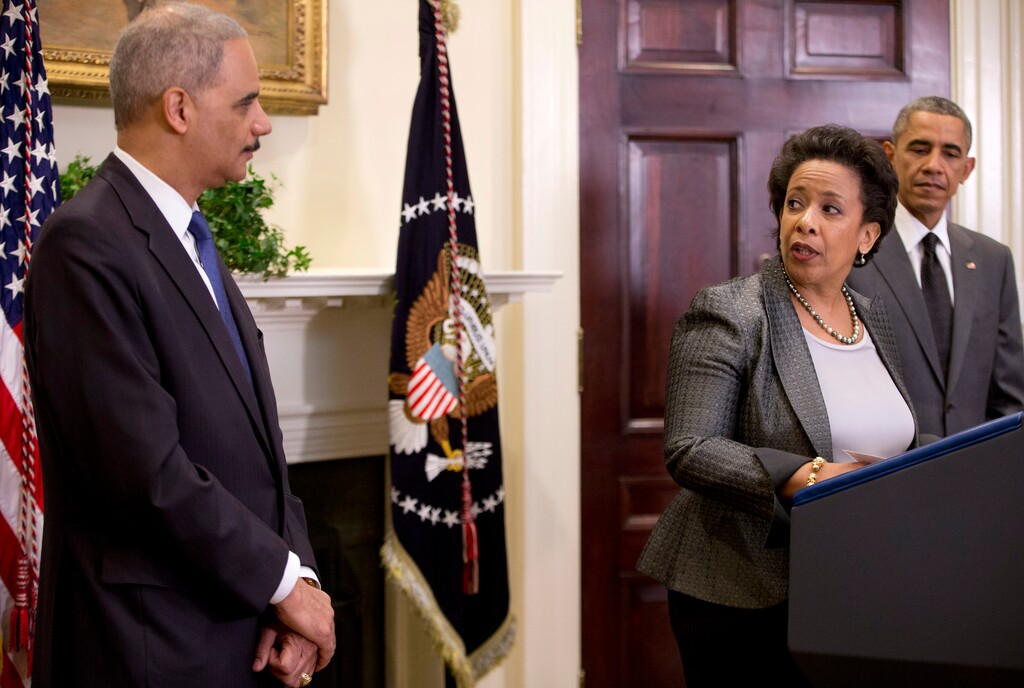 US Attorney Loretta Lynch, center, looks to Attorney General Eric Holder as with President Barack Obama at right, in the Roosevelt Room of the White House in Washington, Saturday, Nov. 8, 2014, where the president announced that he will nominate Lynch to replace Holder as Attorney General. (AP Photo/Carolyn Kaster)