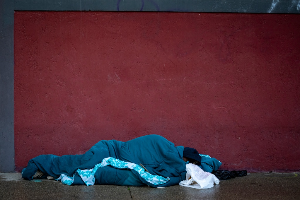 (Rick Egan | The Salt Lake Tribune) A man wraps up in blankets on Rio Grande Street on Saturday, Dec. 27, 2025. The most recent point-in-time count found a decrease in Utah's homeless population.

