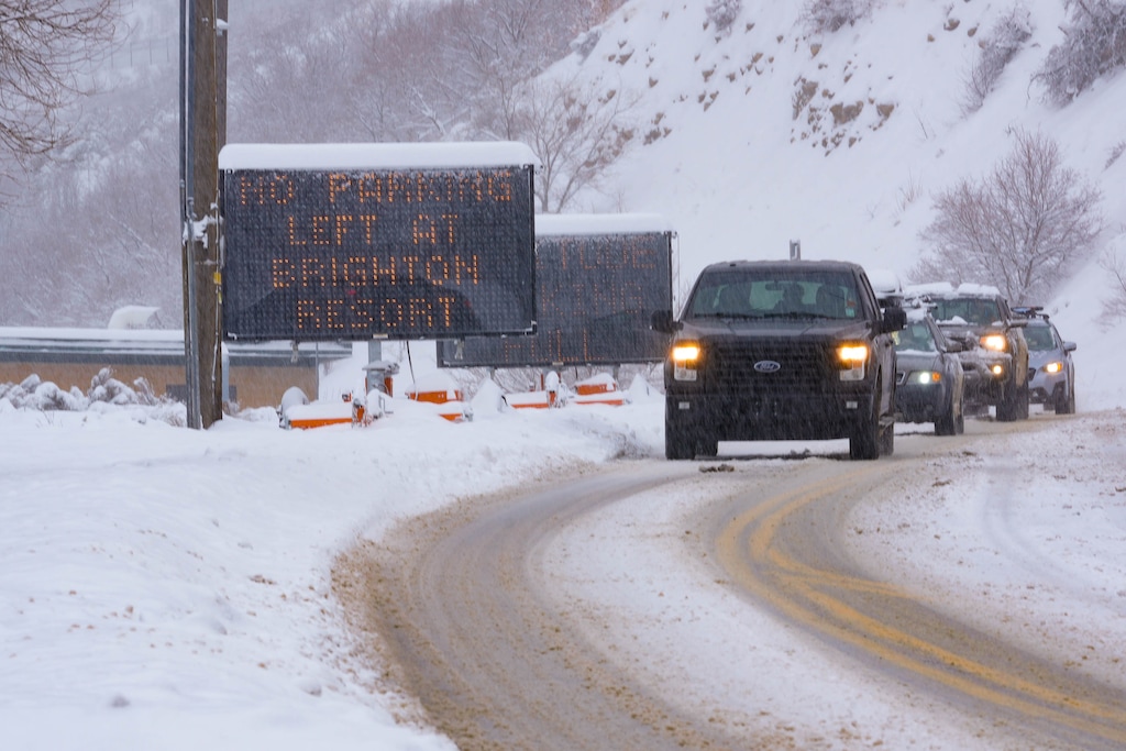 (Francisco Kjolseth | The Salt Lake Tribune) Cars exit Big Cottonwood Canyon as a road sign flashes “no parking left at Brighton resort,” followed by a second notice that reads “seriously, not kidding,” on Wednesday, Feb. 22, 2023. The Salt Lake County Council has increased fines for illegal parking in the Cottonwood canyons.