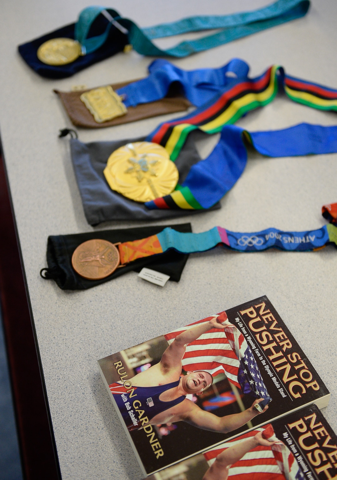 (Francisco Kjolseth  |  The Salt Lake Tribune)  Olympic wrestling champion Rulon Gardner displays his medals and his autobiography "Never Stop Pushing: My Life from a Wyoming Farm to the Olympics Medal Stand" as he meets with students and parents on Wed. May 16, 2018, to introduce himself as the new wrestling coach at Herriman High school. 