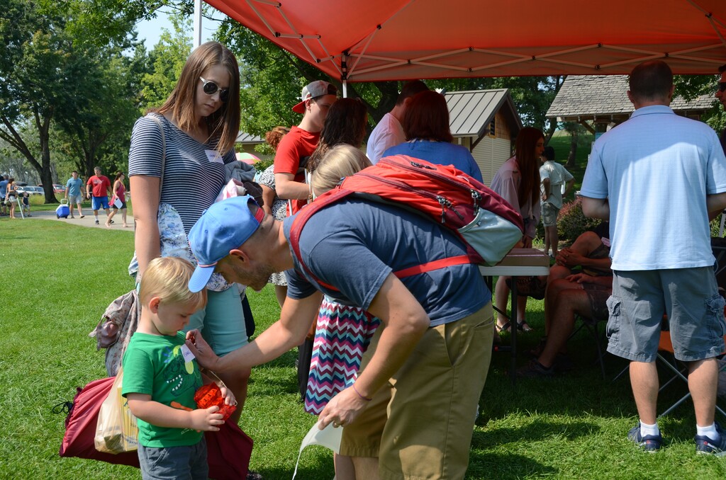 (Nichole Blanchard | Idaho Statesmen) Calen Smith puts a nametag on his son, Isaac, as the family arrives for a Remnant movement conference at Eagle Island State Park on Saturday, Sept. 2. Remnant followers are part of an offshoot of the LDS Church.