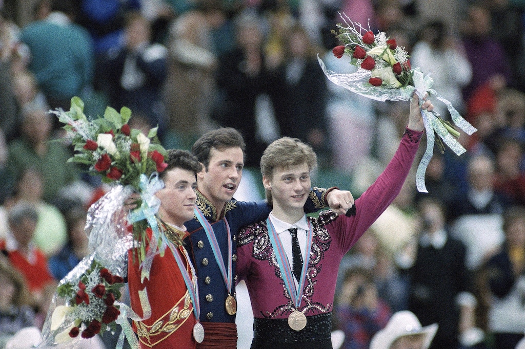 UFILE - In this Feb. 20, 1988, file photo, U.S. figure skater Brian Boitano, center, who won the gold medal is flanked by silver medalist Brian Orser , left, of Canada, and bronze medalist Alexandre Fadeev, right, of the Soviet Union, at the medal ceremony following the men's figure skating competition at the Winter Olympics in Calgary, Canada. U.S. figure skater Vincent Zhou is well-versed in the rivalry between American figure skater Brian Boitano and Canadian counterpart Brian Orser, what became known as the “Battle of the Brians” at the 1988 Calgary Olympics. That’s because Boitano is “an inspiration” to Zhou, who fell in love with the sport by watching the sport in part by watching old footage of the two-time world champion on Youtube. (AP Photo/Jack Smith, File)