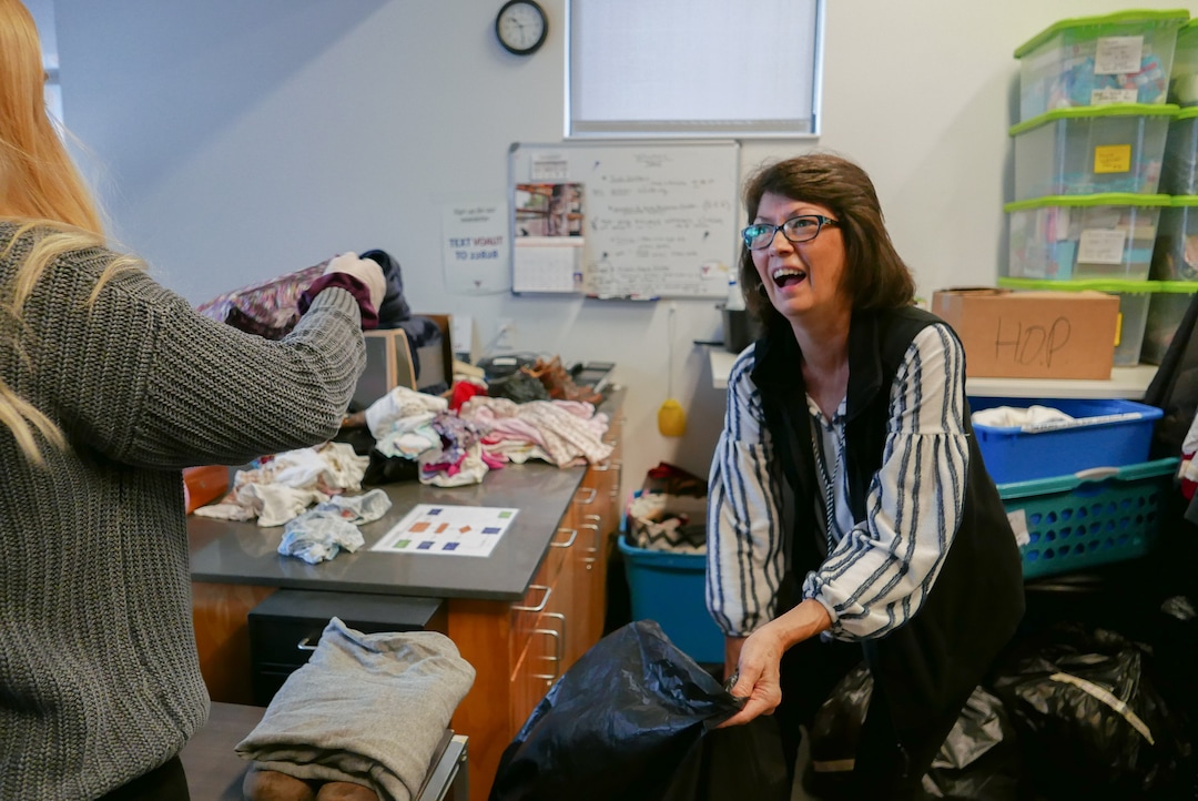 (Clara Hatcher | The Salt Lake Tribune) Kathy Wagner, a VOA volunteer, laughs while sorting through donations at the Youth Resource Center.
