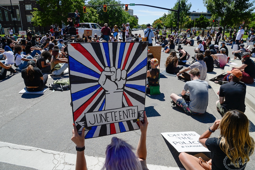 (Francisco Kjolseth  |  The Salt Lake Tribune) Demonstrators stop to protest outside the Salt Lake City Public Safety Building as part of a series of Juneteenth celebrations on Friday, June 19, 2020.