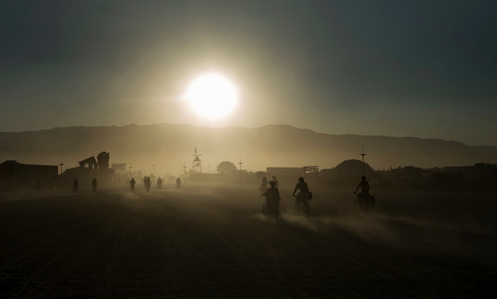 (Rick Egan  |  The Salt Lake Tribune)  Cyclists pedal through the dusty playa, during Burning Man. Saturday, September 2, 2017.
