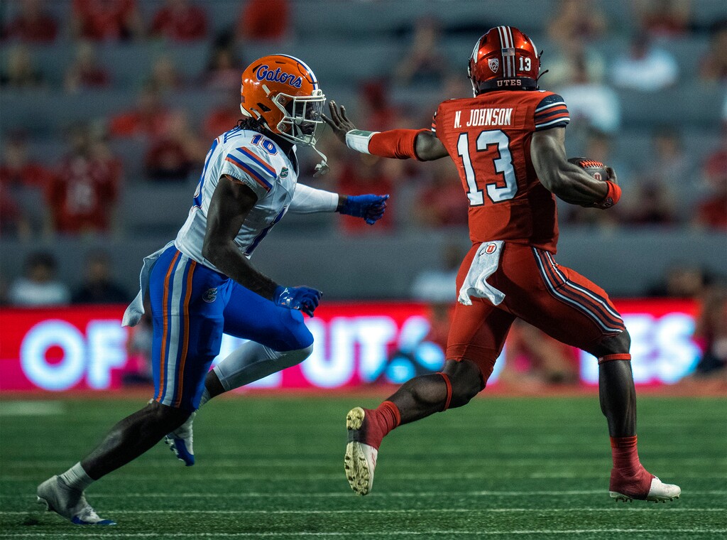 (Rick Egan | The Salt Lake Tribune) Utah Utes quarterback Nate Johnson (13) tries to get past Florida Gators safety Miguel Mitchell (10), in football action between the Utah Utes and the Florida Gators, at Rice-Eccles Stadium, on Thursday, Aug. 31, 2023.