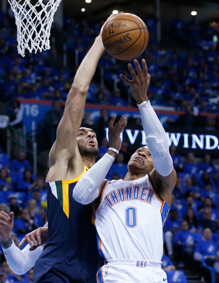 Utah Jazz center Rudy Gobert, left, blocks a shot by Oklahoma City Thunder guard Russell Westbrook (0) in the first half of Game 1 of an NBA basketball first-round playoff series in Oklahoma City, Sunday, April 15, 2018. (AP Photo/Sue Ogrocki)