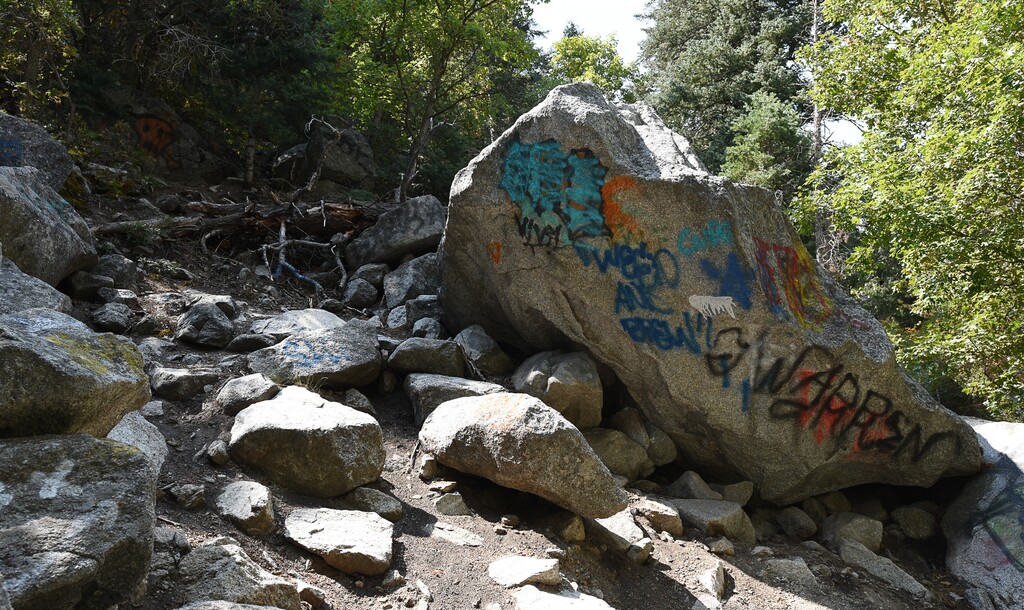(Francisco Kjolseth  |  The Salt Lake Tribune)  Graffiti has proliferated in lower Little Cottonwood Canyon, where vandals, often wielding cans of florescent-colored spray paint, have covered granite faces, trees and structures. The vandalism is particularly apparent along the Temple Quarry Trail and the creek at the Moon Rock swimming hole and former pavilion site. Volunteers using donated equipment and solvents spend thousands of hours removing the paint from the rocks only to see graffiti return to the same faces or on rock nearby.
